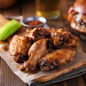 bbq chicken wings on wooden tray